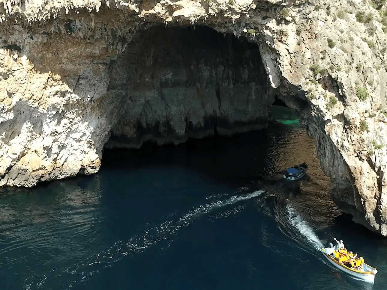 Botes malteses entrando bajo el arco de la Blue Grotto