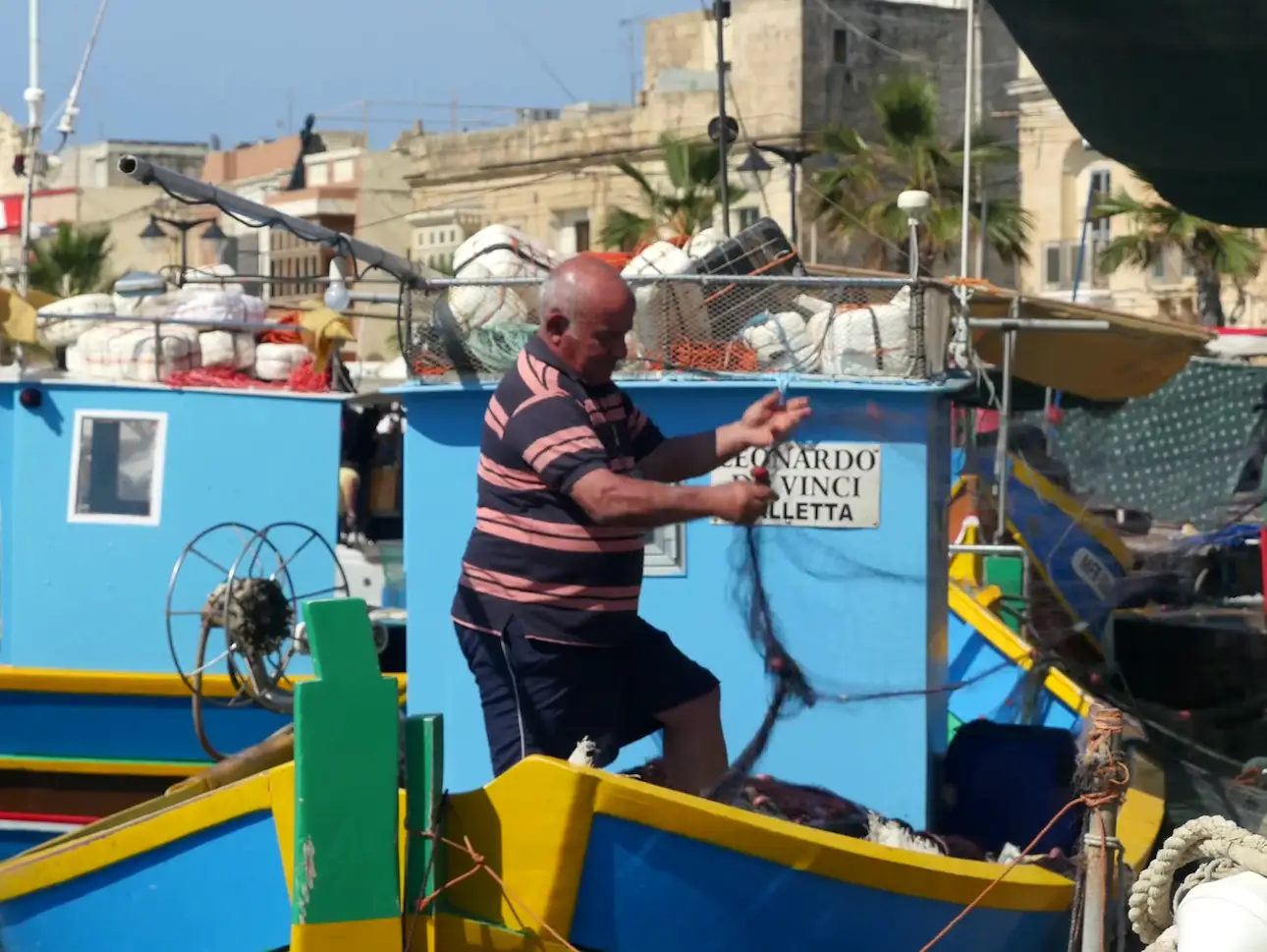 Pescador maltés deshaciendo sus redes de pesca