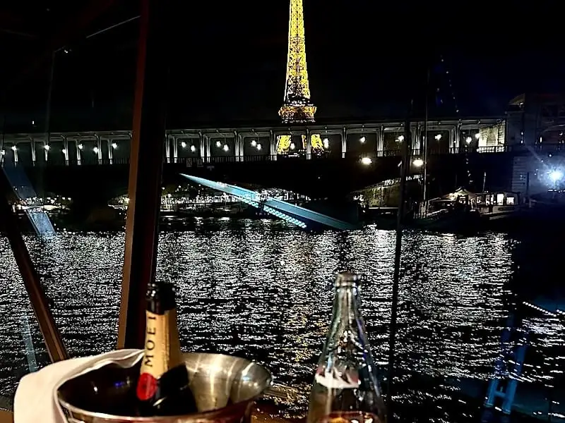 Botella de champán con vista a la Torre Eiffel desde el Sena