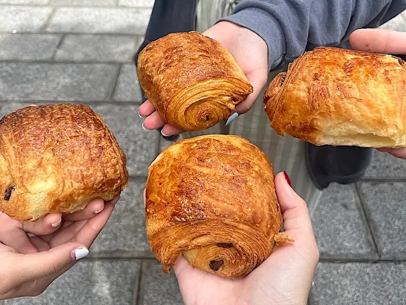 Cuatro manos sosteniendo cuatro pain au chocolat