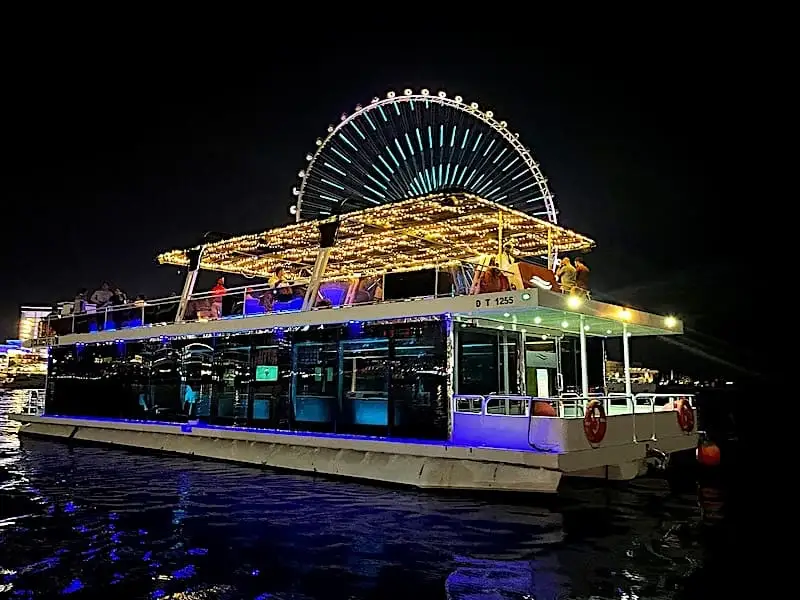 Barco de cena crucero frente a la rueda de Dubái