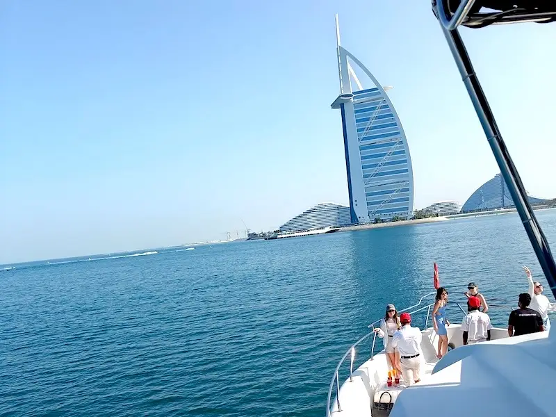 Yate en la Marina de Dubái frente a la torre Burj al Arab