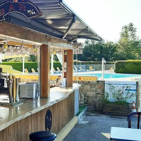 Bar extérieur avec vue sur la piscine au camping de l'étang