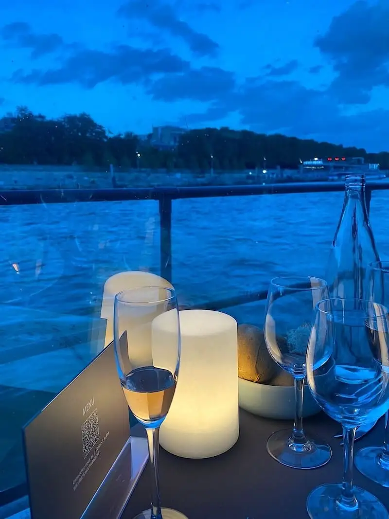 Evening aperitif on the Seine Glass of white wine by the Seine at night
