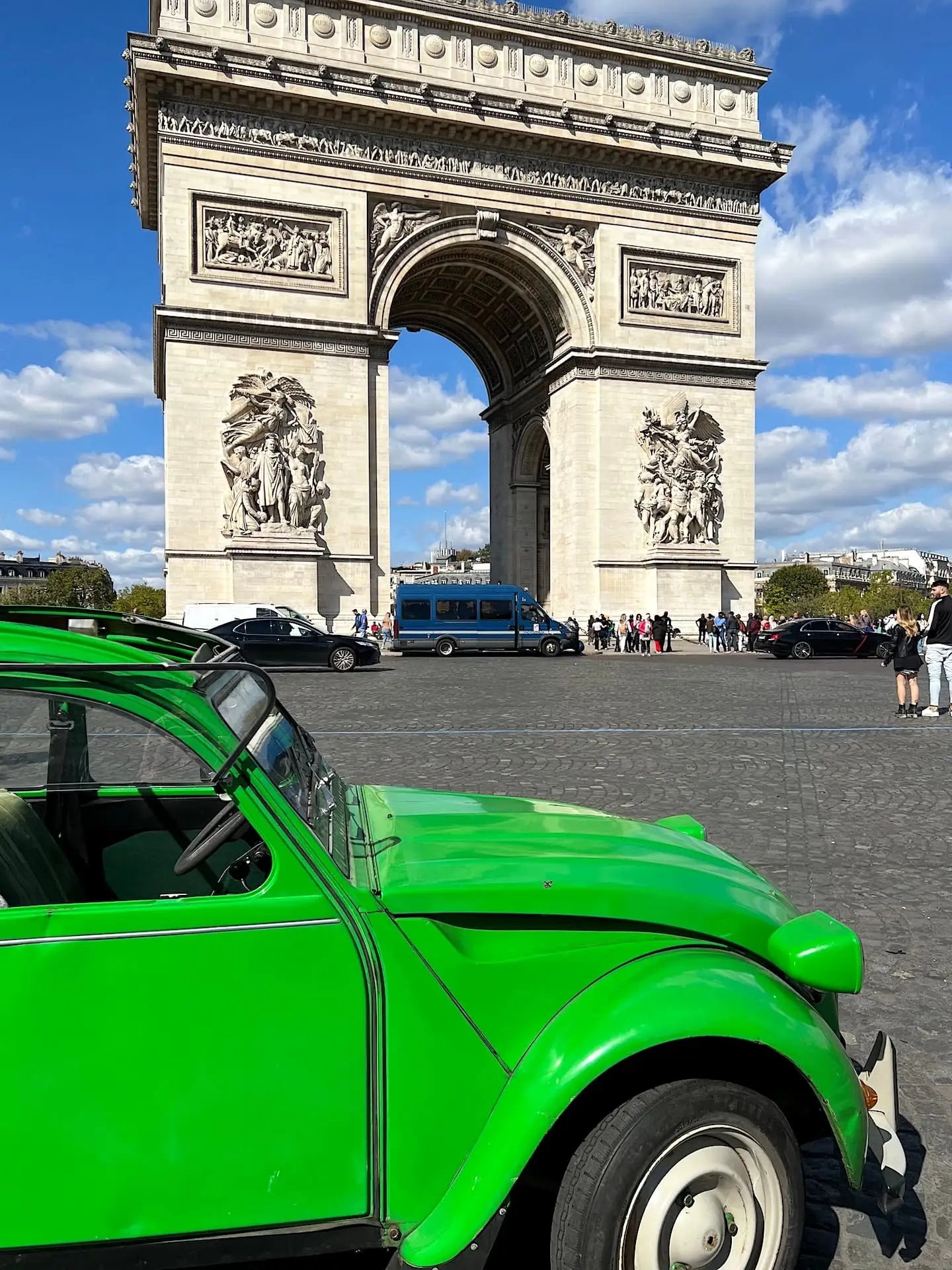Green Deux Chevaux (2CV) car in front of the Arc de Triomphe